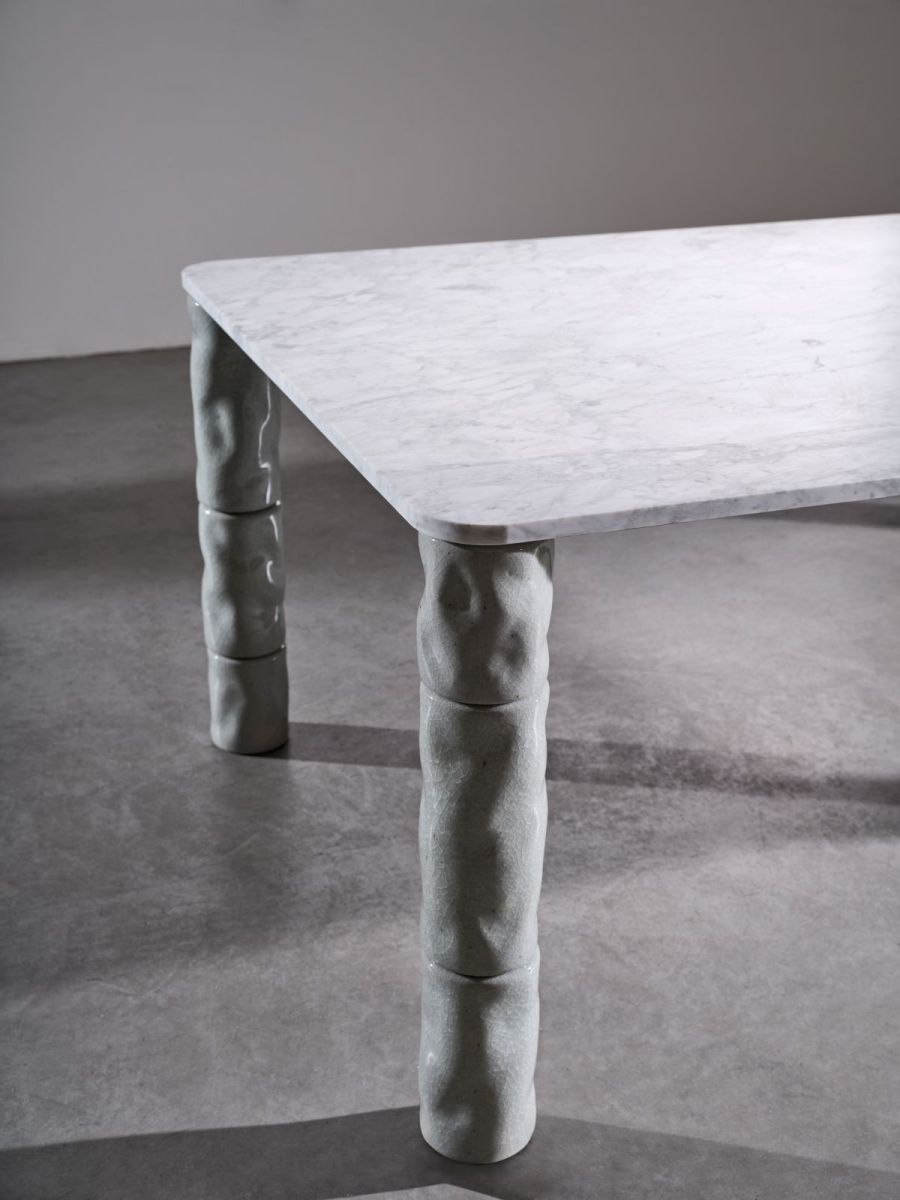 Tavolo Brick (design Paola Navone) di Gervasoni, con piano di marmo di Carrara levigato e gambe composte da cilindri torniti a mano di porcellana bianca e sabbia vulcanica.